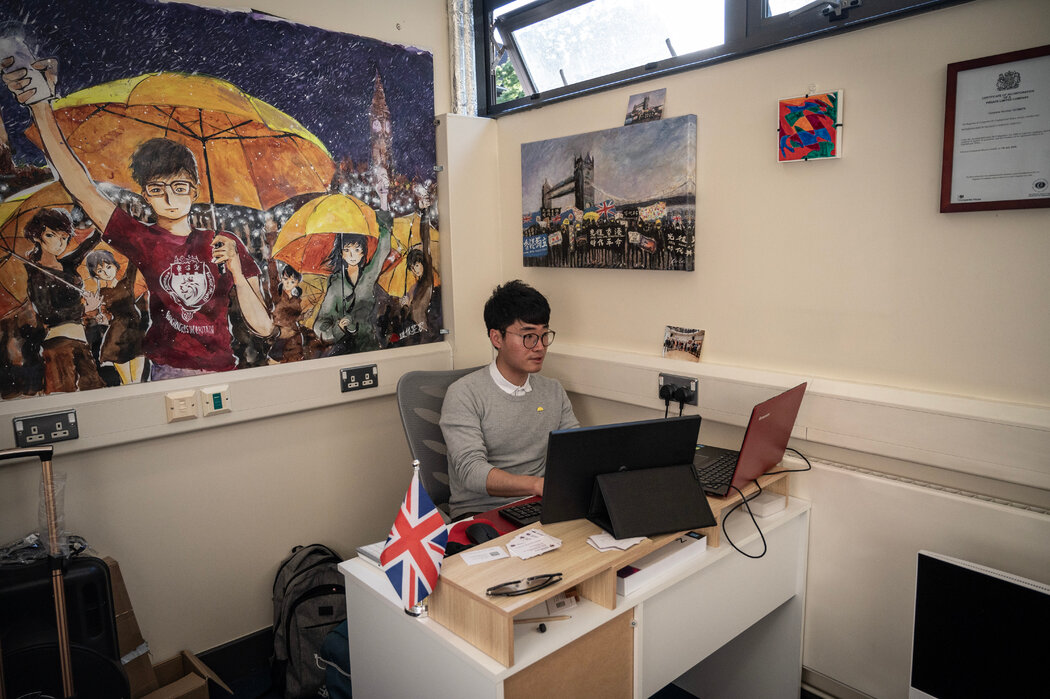 香港活動人士鄭文傑上週在英國港僑協會辦公室，他目前居住在英國。在他身後的畫作中，香港抗議者們舉著標誌性的黃色雨傘。