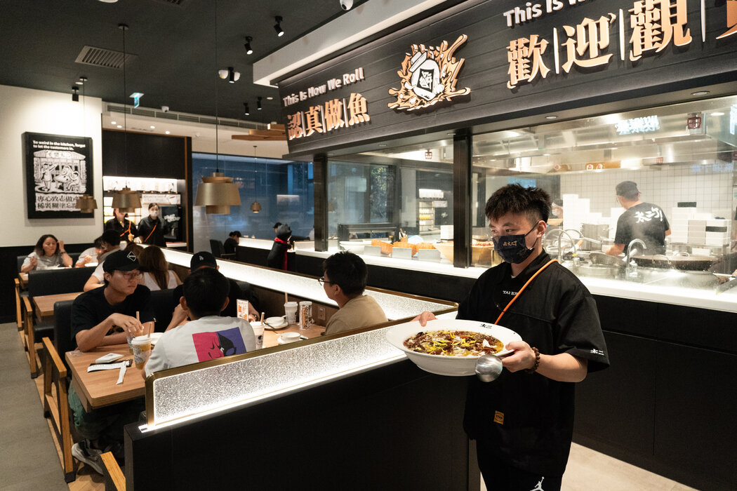 太二酸菜魚的服務員正在給顧客上菜。