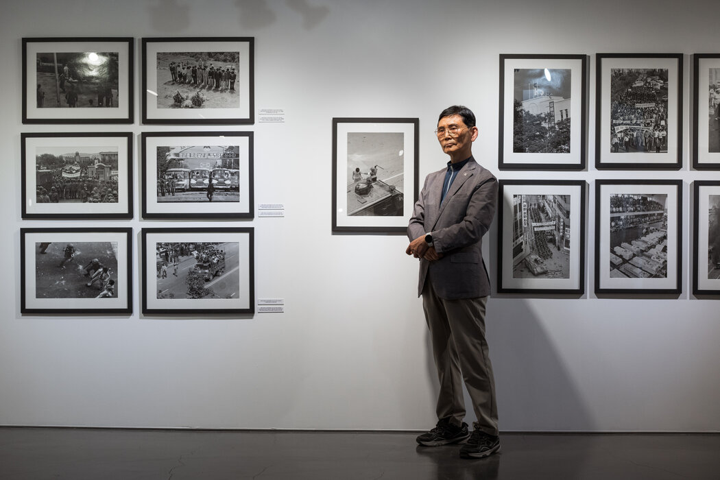 本月，在韓國光州舉辦的關於1980年光州民主運動的展覽上，羅庚澤與他的攝影作品合影。
