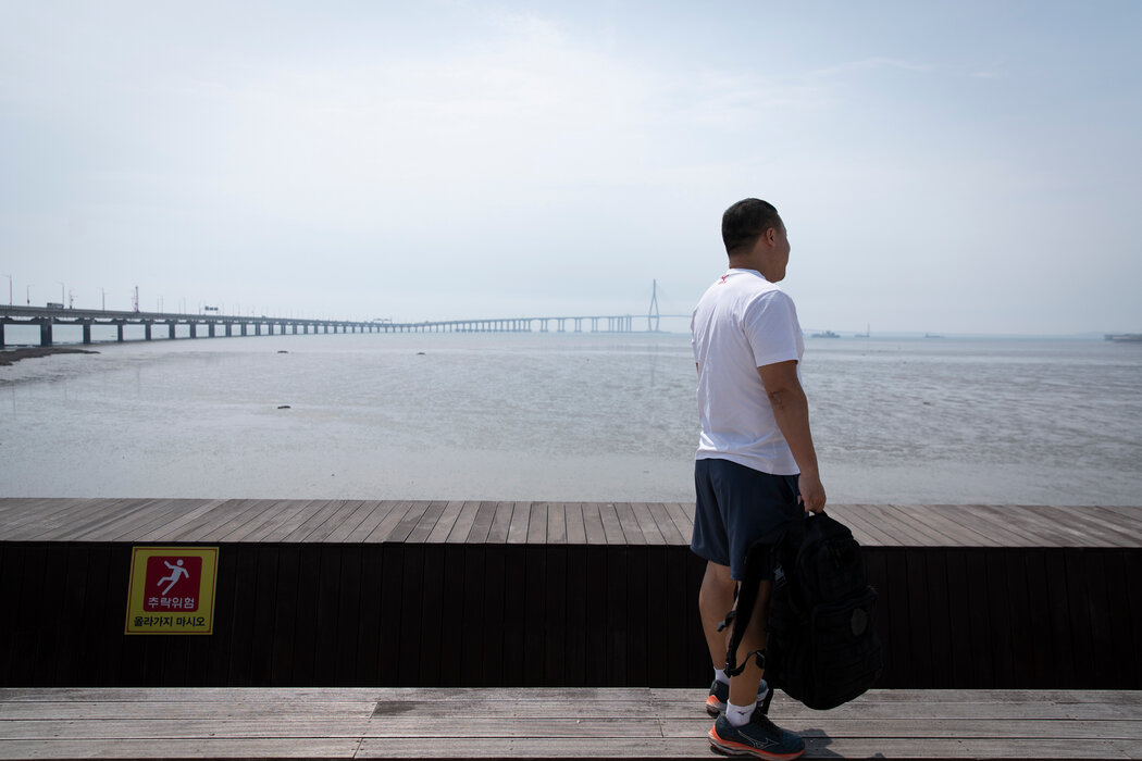權平注視著他去年登陸的韓國仁川的泥灘。