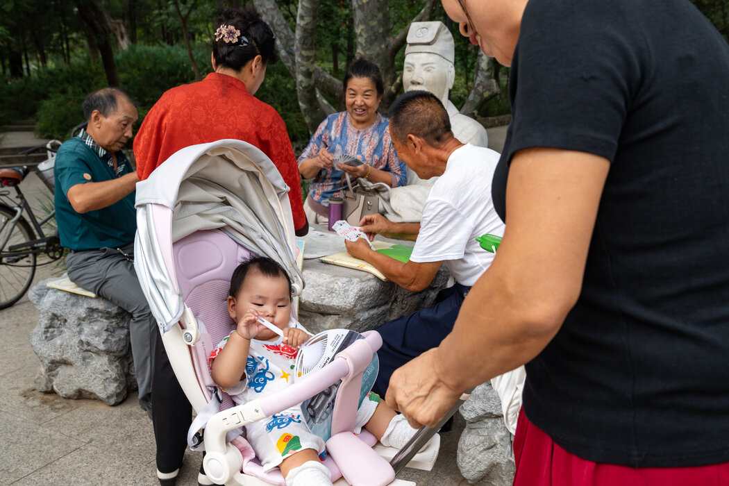 在密雲公園的另一處，一群上了年紀的居民在嬰兒車旁打牌。