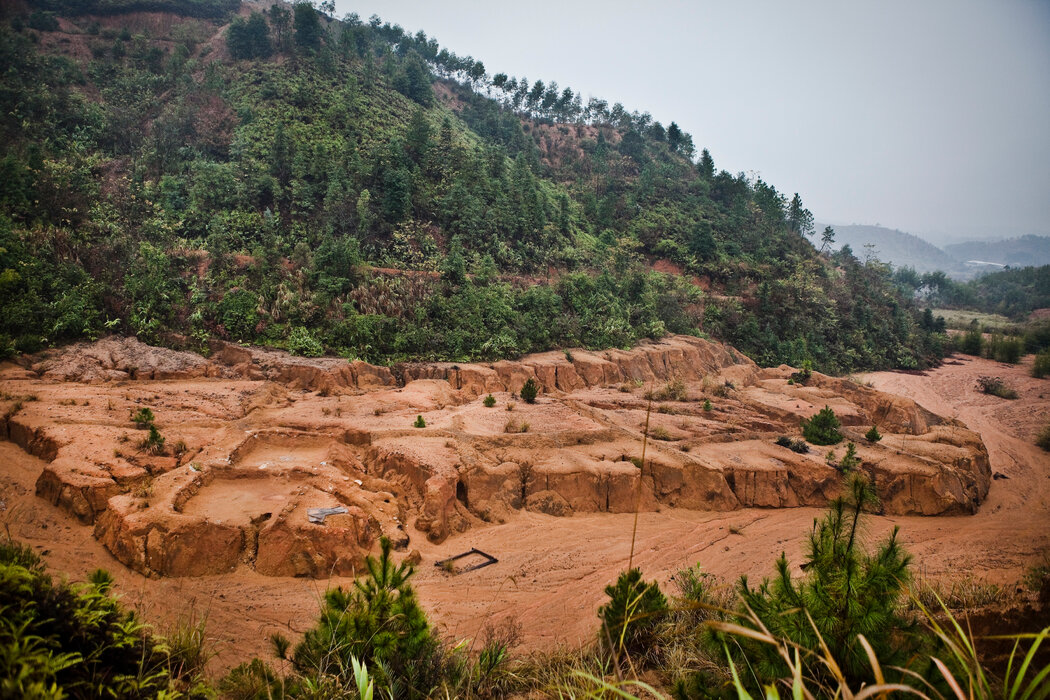 2009年，中國南部古雲村一個廢棄稀土礦的酸坑流出的酸液污染了曾經鬱鬱蔥蔥的山谷稻田。