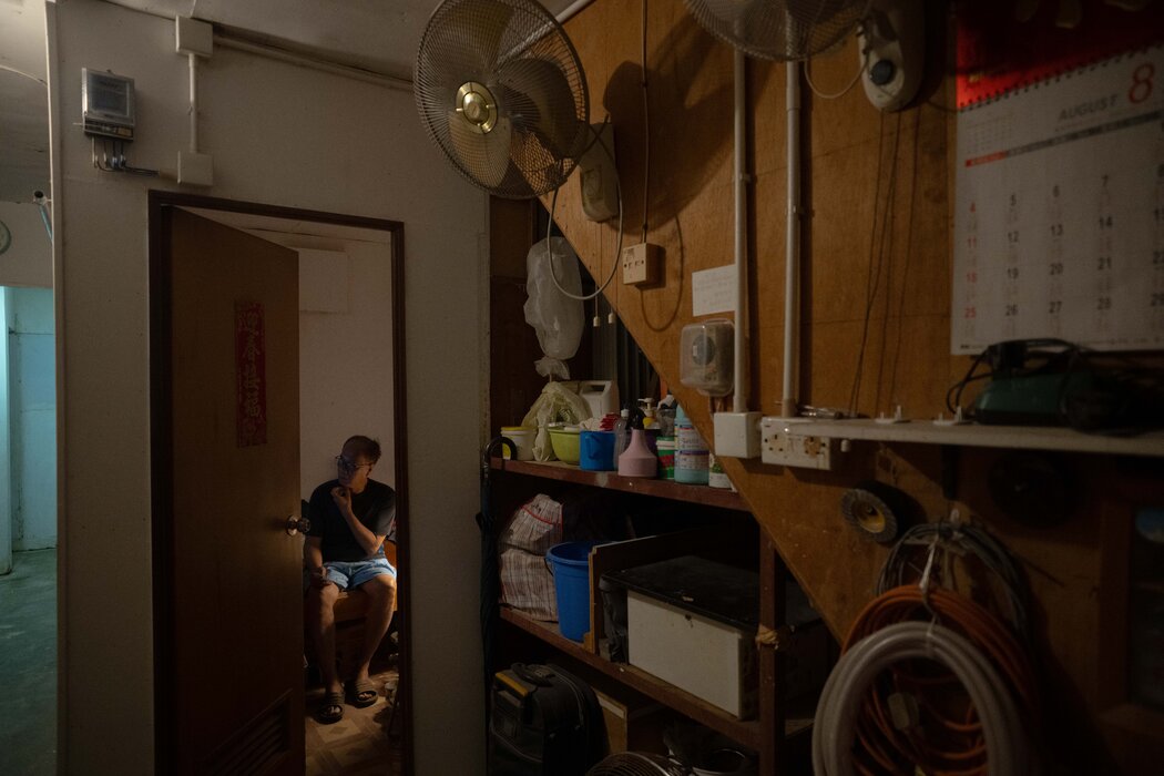本·石在位於觀塘的劏房裡看電視。