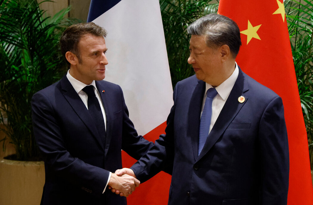 週二,在巴西里約熱內盧舉行的二十國集團峰會期間,法國總統馬克宏(左)在雙邊會談中與中國國家主席習近平握手。