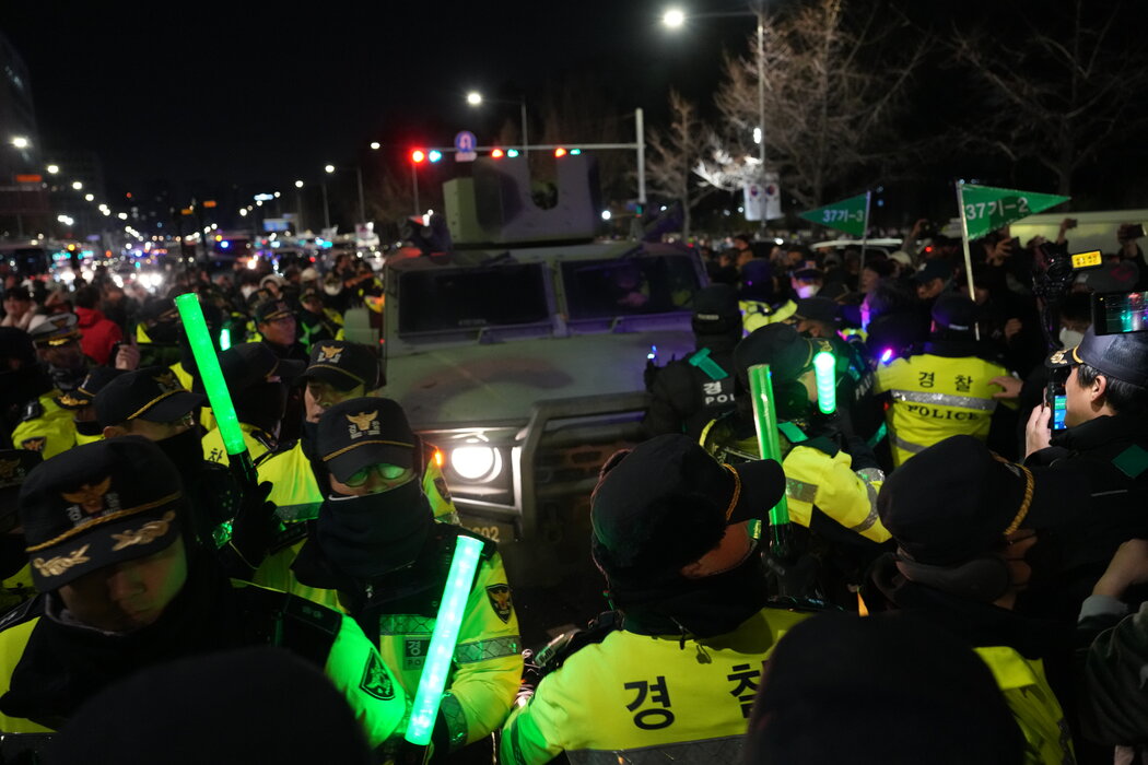 韓國總統尹錫悅宣布緊急戒嚴後，抗議者在首爾的國會大廈外阻擋一輛軍車，攝於週三。