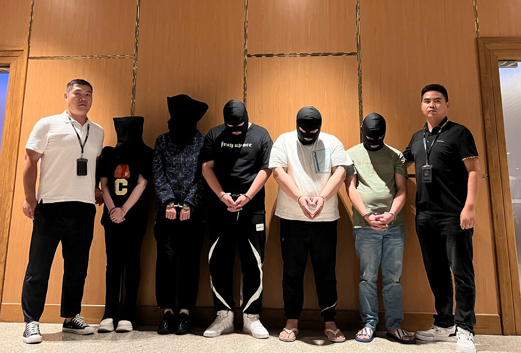 2023年，仰光國際機場，兩名警察中間是五名被控電信和網路詐騙的嫌疑人。