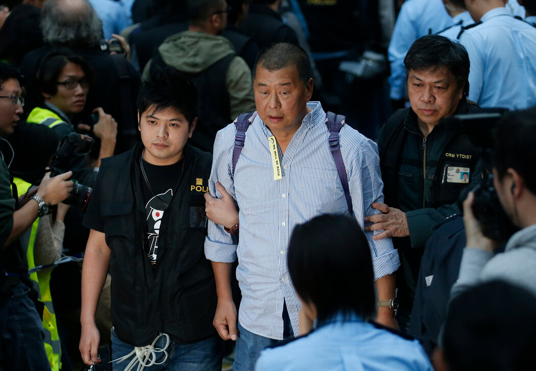 2014年，黎智英（中）在警察的押送下離開抗議區。