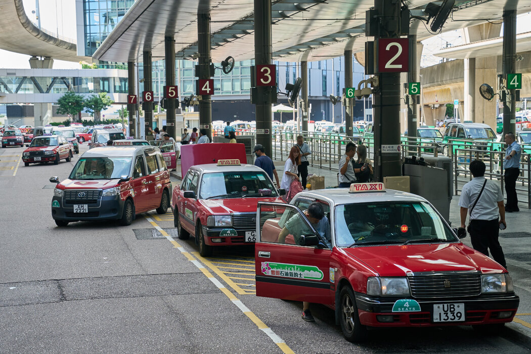 計程車在香港國際機場接客，攝於去年夏天。機場工作人員經常需要在計程車站提醒遊客，許多的士只接受現金。