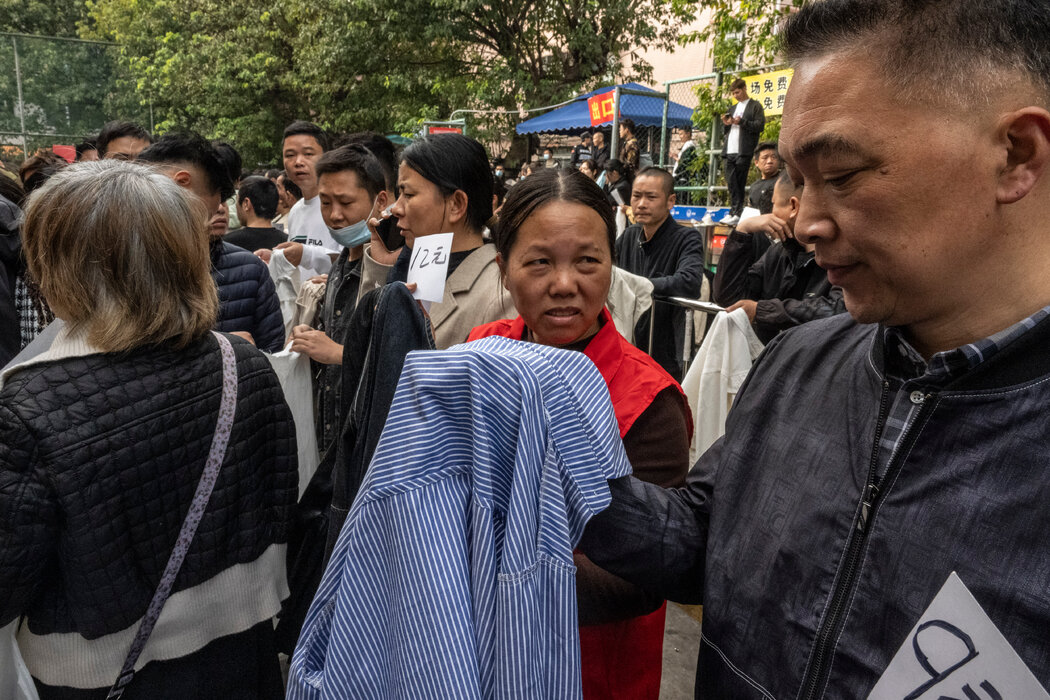 在廣州的勞動市場，招工的服裝廠經理用樣品來說明工作崗位的技術要求。