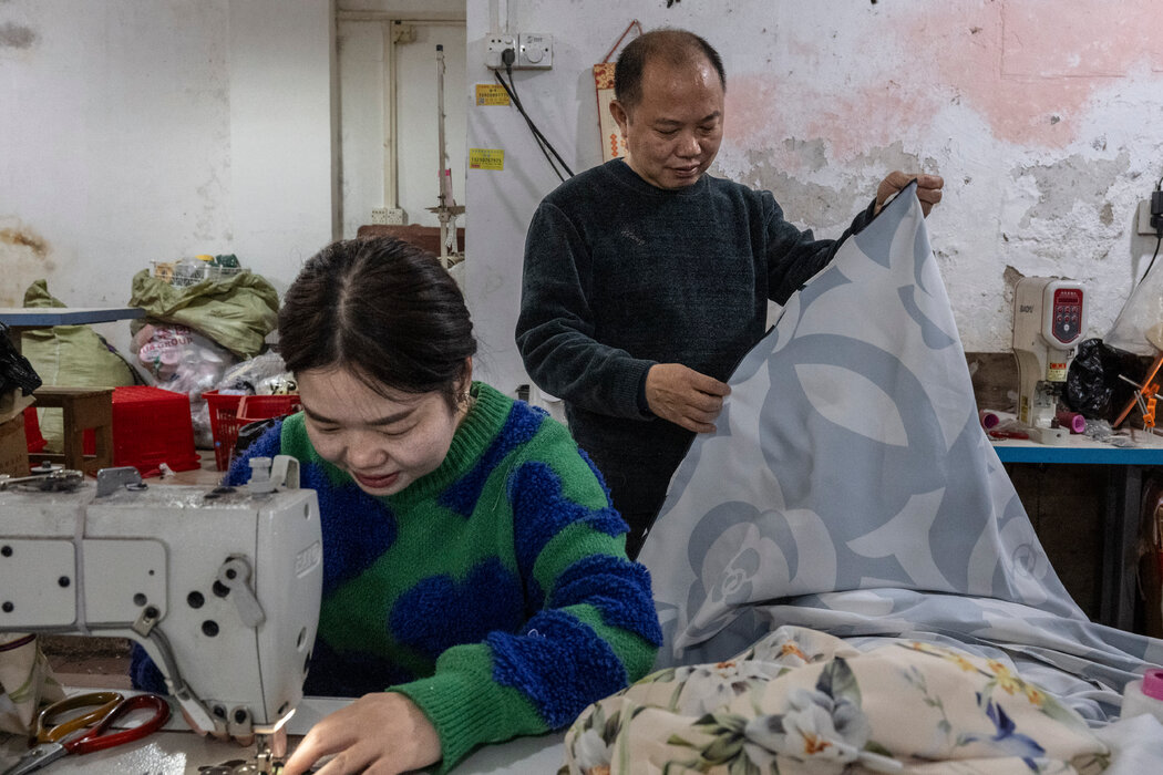 站在工人身後的惲從平說,他在廣州的這家服裝作坊依賴出口業務。