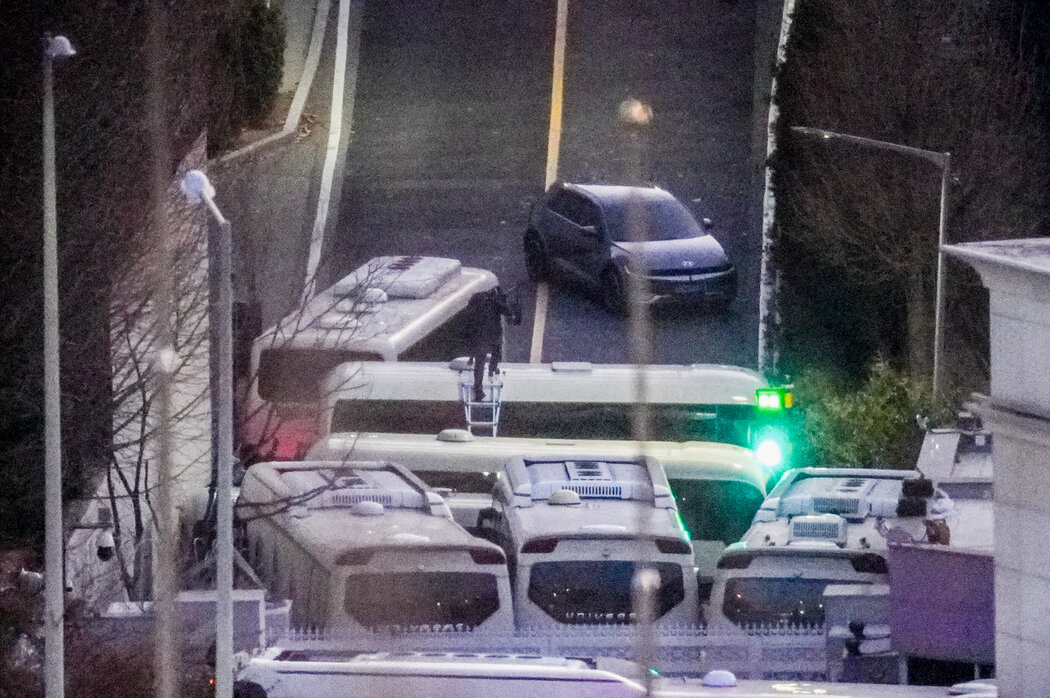 週三,一名警察爬上梯子,越過一輛堵住通往尹錫悅首爾住宅道路的大巴。