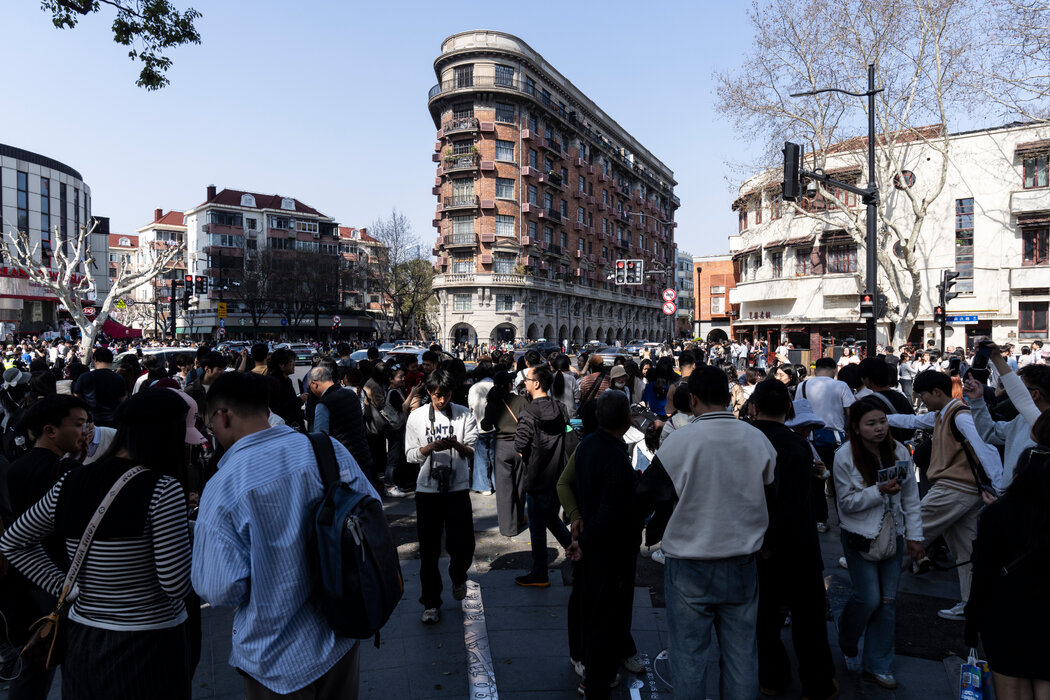 在上海的市中心，正在給一座歷史建築拍照的遊客。