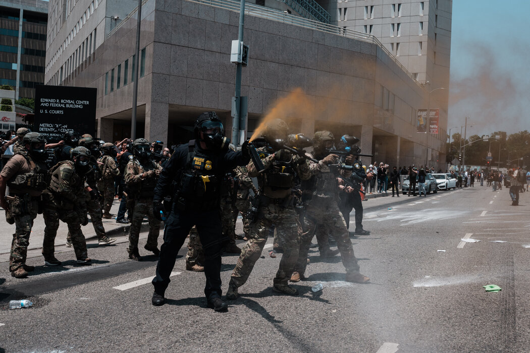 執法人員和加州國民警衛隊隊員在洛杉磯市中心與抗議者交鋒,攝於週日。