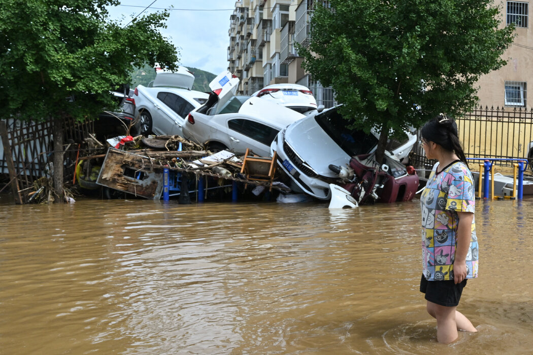 在密雲一處被洪水淹沒的街區，有多輛車受損，攝於週二。