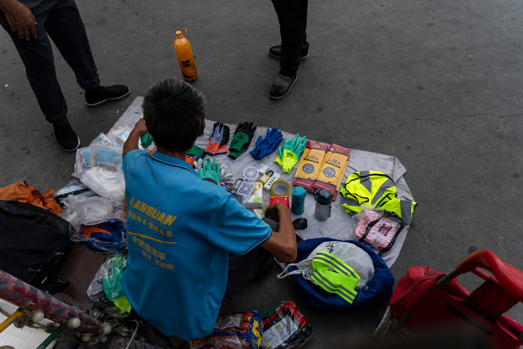 在十字路口向打零工者兜售廉價防護裝備的人。