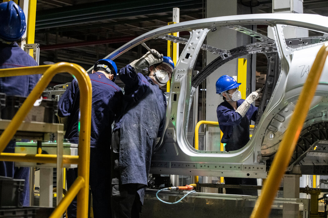 電動汽車工廠生產線上的工人。