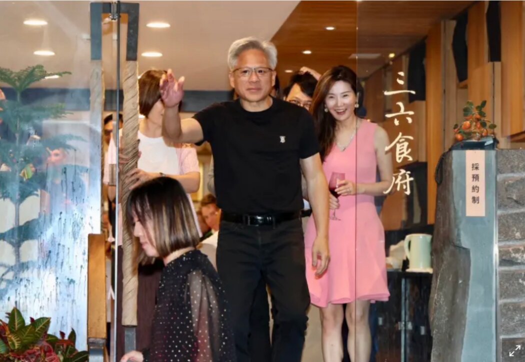 黃仁勛從一家餐館出來,一些人跟在他身後。這張照片是台灣媒體「今日新聞」拍到的。