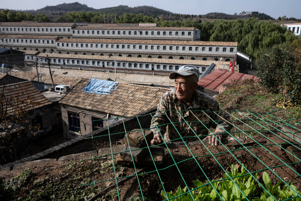 賈天連在大寨耕作他那塊小小的土地。這個位於中國北部的村莊曾被毛澤東譽為全國的典範。背景中矗立著那個年代的「人民公社」住宅樓。