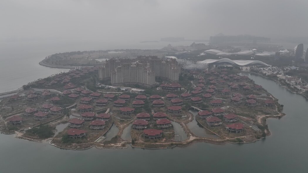 中國海南的海花島項目佔地廣闊，包括一座購物中心、一座會議中心、多棟高層公寓以及一座酒店，四周環繞著數十棟未完工的別墅。