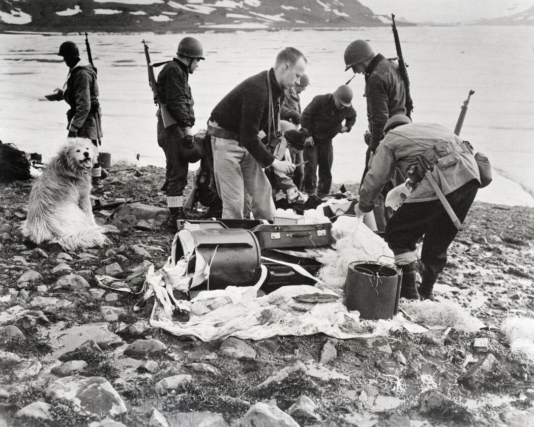1943年，美軍襲擊格陵蘭海岸外一座島嶼上的德國電台和氣象基地後，檢查撤退的納粹遺棄的降落傘裝備。