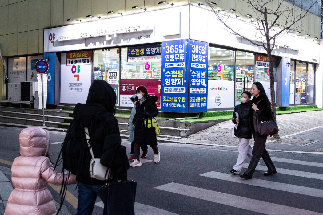 母親和孩子們走過首爾大峙洞地區一家藥房。