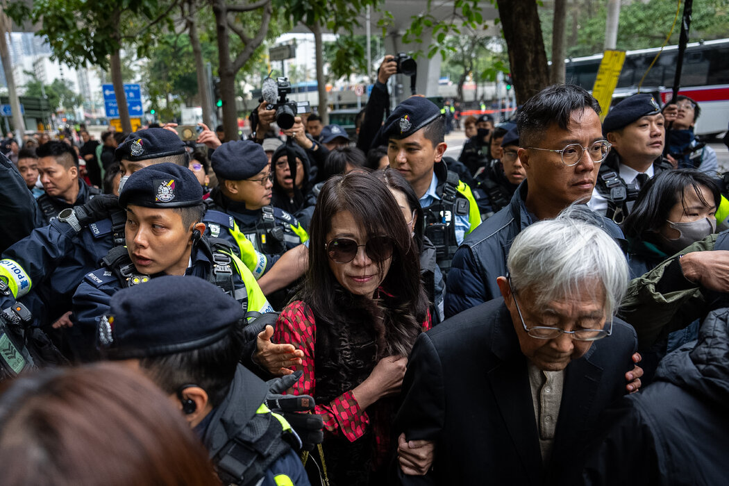 週一,黎智英的妻子李韻琴(中)離開法院,身邊都是警察。