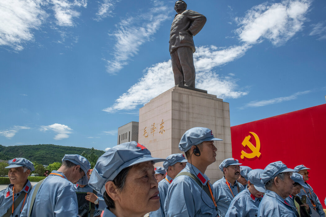 身著紅軍制服的遊客在延安革命紀念館毛澤東雕像旁合影。
