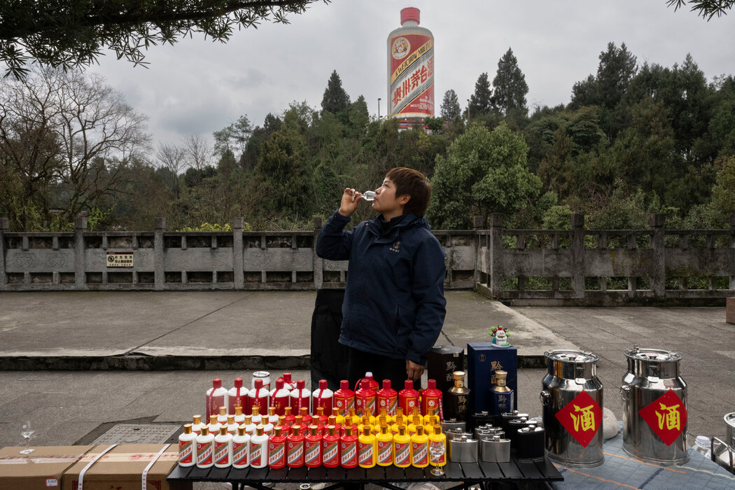 袁媛在公園外推廣黔醉酒業的白酒，小山上矗立著巨型瓶裝的貴州茅台。