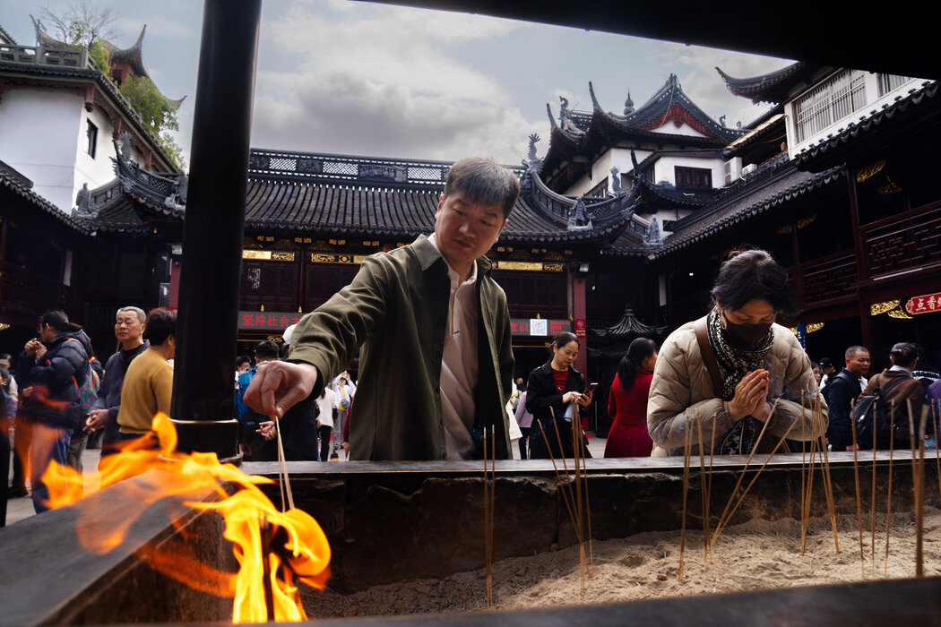 遊客在豫園附近的一座寺廟裡供奉香火。