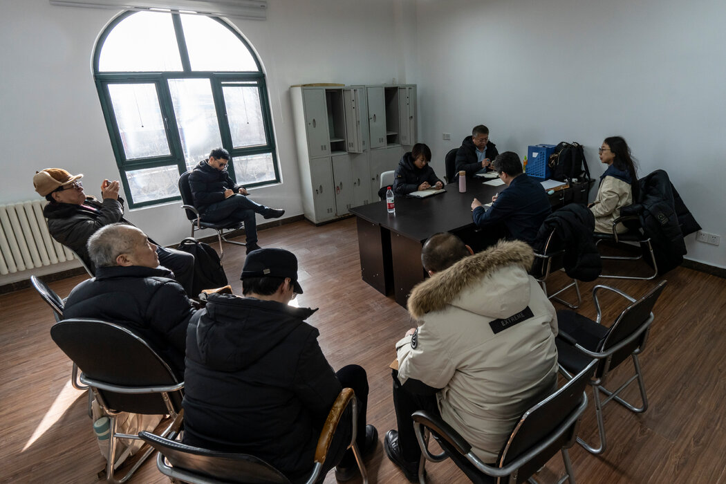 拿著手機的柳信中和在他右側的賀樹忠以及其他人正與當地政府舉行仲裁會議。