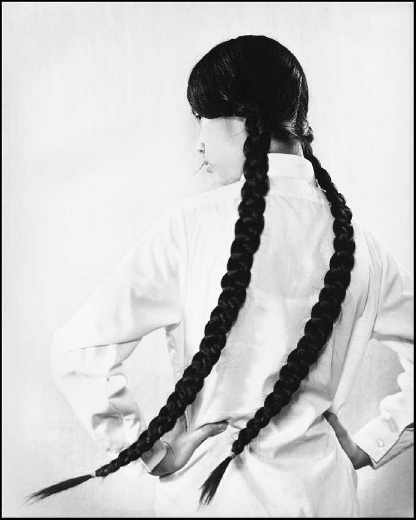 在《長髮女孩》這幅作品中，一名女子背對鏡頭，側目而視，神情倔強。