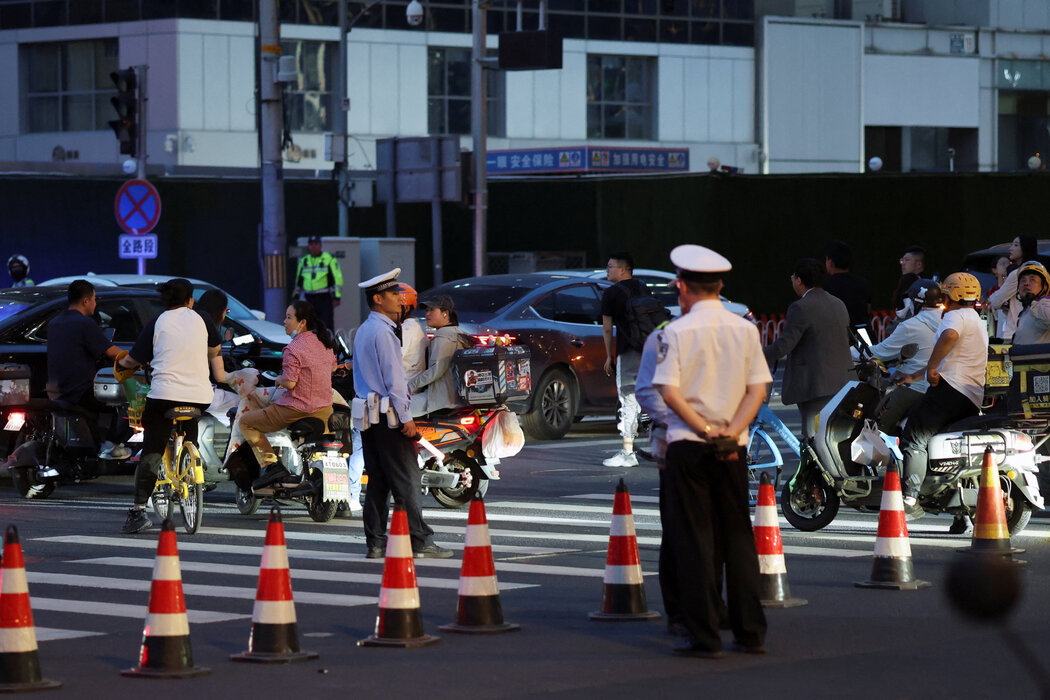 警察在靠近中信大廈的十字路口巡視,大廈外牆高層可見受損。