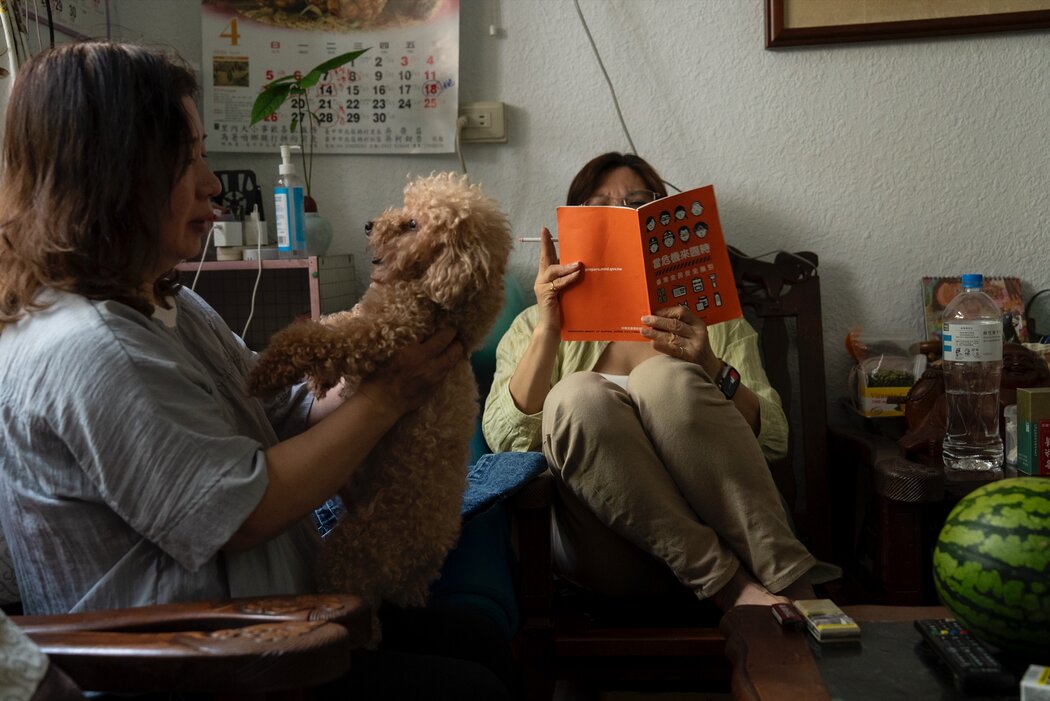 在台灣西部，一名女子正在閱讀《台灣全民安全指引》，該指引提供應對自然災害和軍事衝突的準備說明。