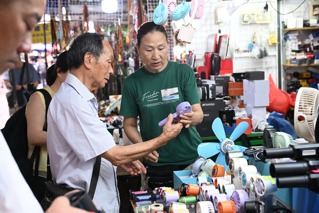 6月,人們在香港一家商店裡選購便攜風扇。