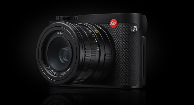 A black Leica Q3 camera with a 28mm lens is centered against a black background with a subtle reflection at the bottom.