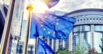European Union flags wave outside the government building.