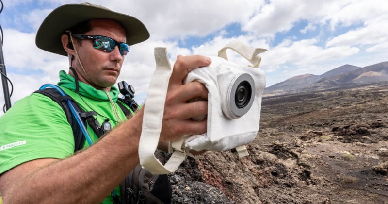 Man, Thomas Pesquets, testing a camera designed for astronauts.