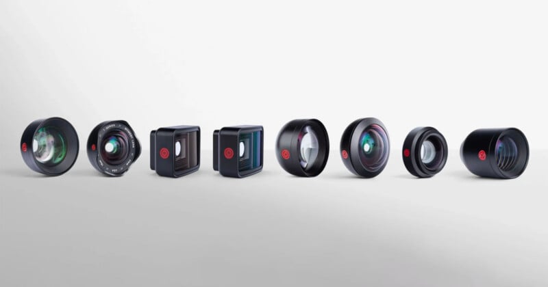 A row of seven different camera lenses and lens attachments, each with distinct shapes and glass elements, displayed against a plain white background.
