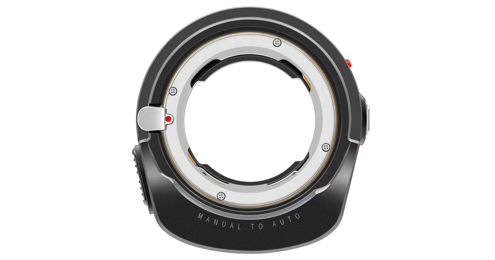 A close-up of a black camera lens adapter with metallic contacts and mounting points. The words "MANUAL TO AUTO" are etched at the bottom of the adapter.