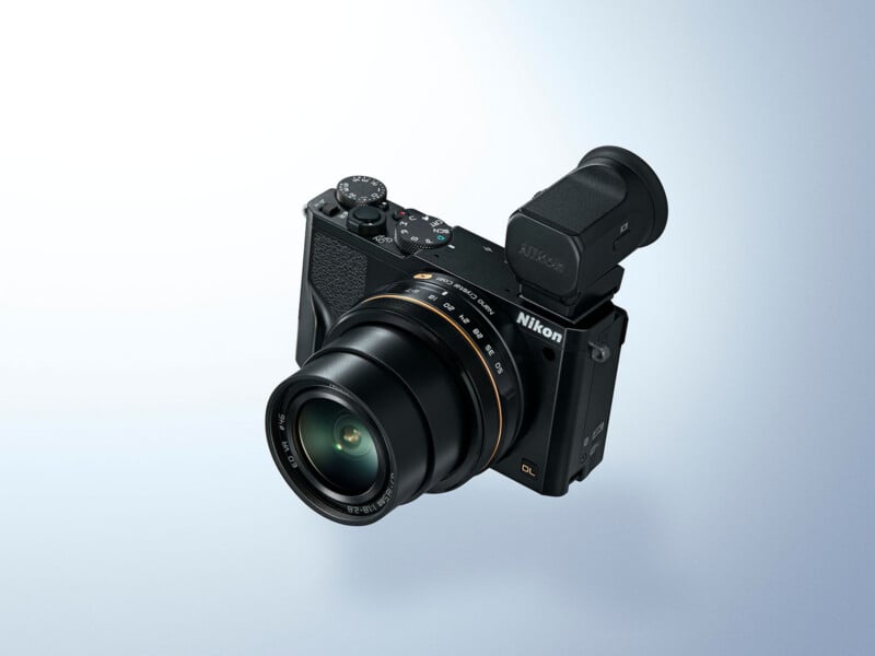 A Nikon digital camera with a large lens and viewfinder is angled against a light blue gradient background. The camera has control dials on top and a textured grip on the right side.