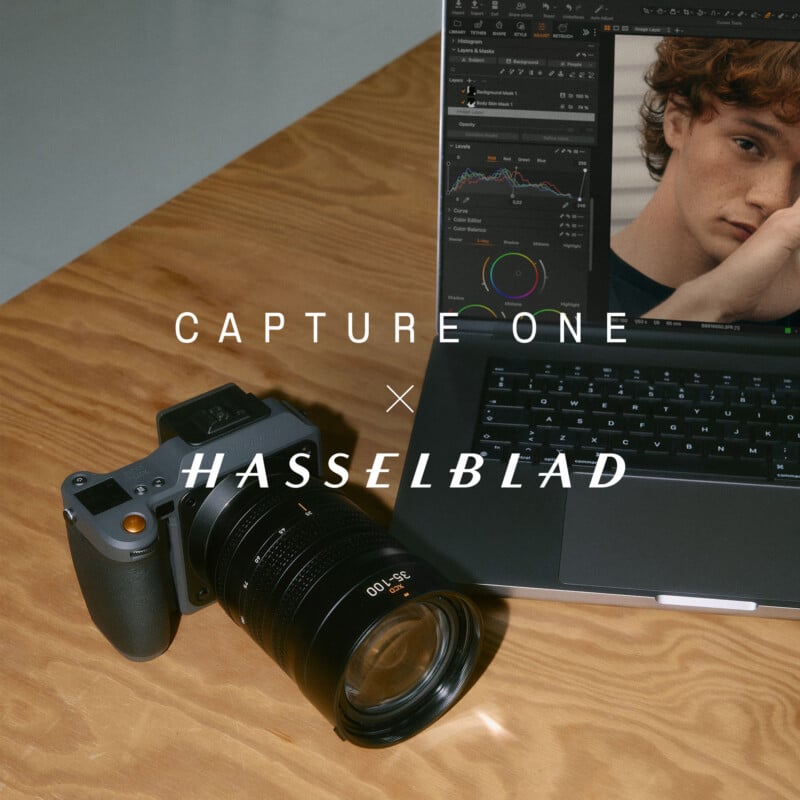 A Hasselblad camera sits on a wooden table next to a laptop displaying photo editing software with a portrait on the screen. Text reads "Capture One x Hasselblad.