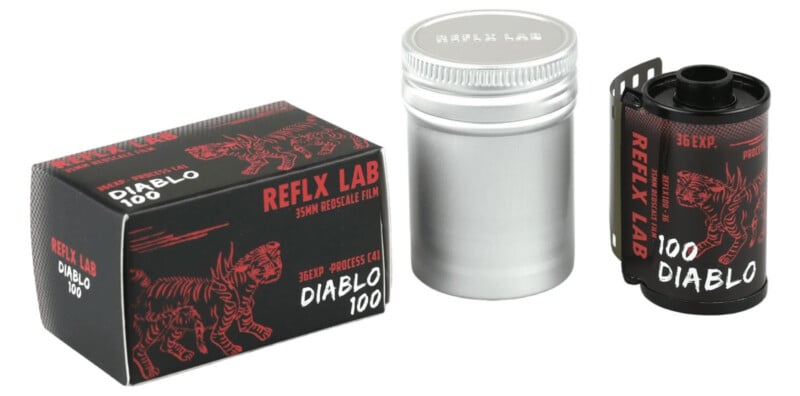 A box, metal canister, and roll of 35mm film labeled “REFLX LAB DIABLO 100” with red and black tiger graphics, positioned on a white background.