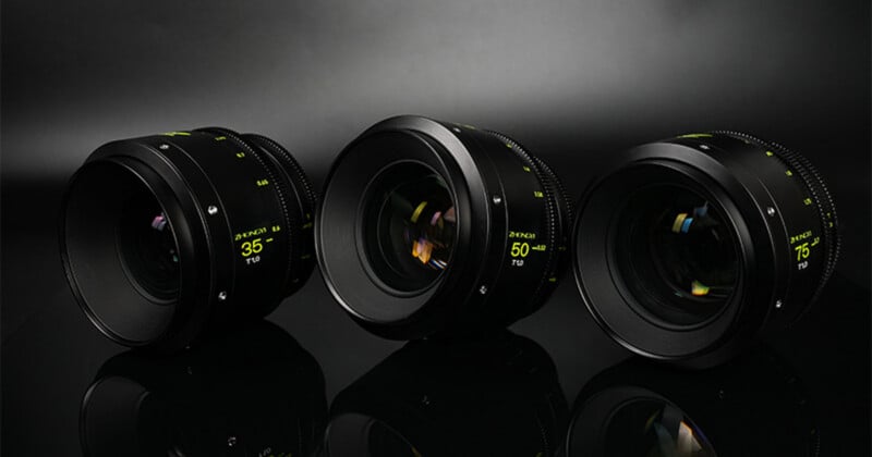 Three camera lenses labeled 35mm, 50mm, and 85mm are arranged side by side on a reflective black surface with a dark, softly lit background.