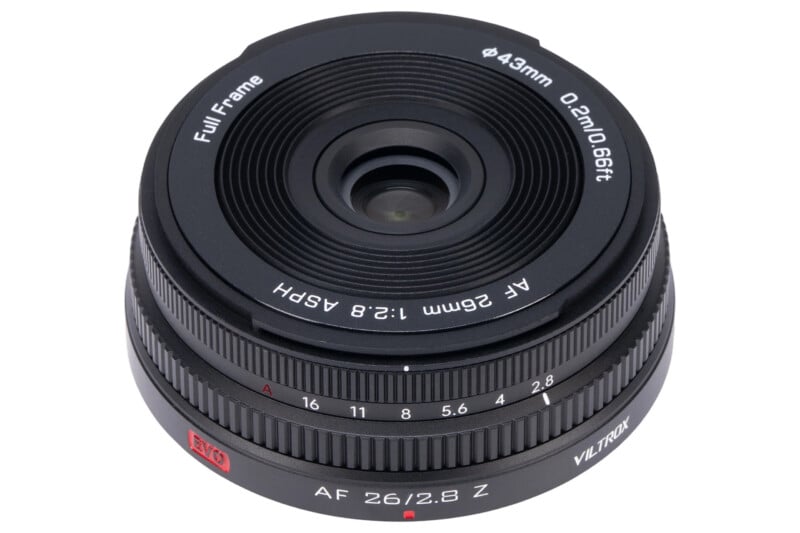 A Viltrox AF 26mm f/2.8 Z full-frame camera lens is shown from above, displaying its glass elements, focus ring, aperture markings, and distance scale.
