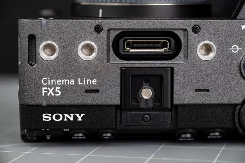 Close-up of a Sony Cinema Line FX5 camera body, showing connection ports and mounting points on a gray surface.