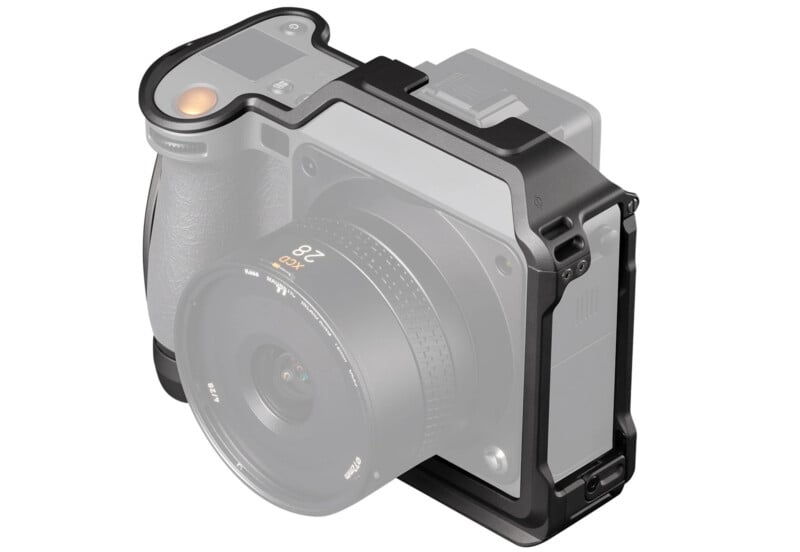 A black protective camera cage attached to a medium-format camera with a 28mm lens. The cage surrounds the camera, providing extra mounting points and protection.