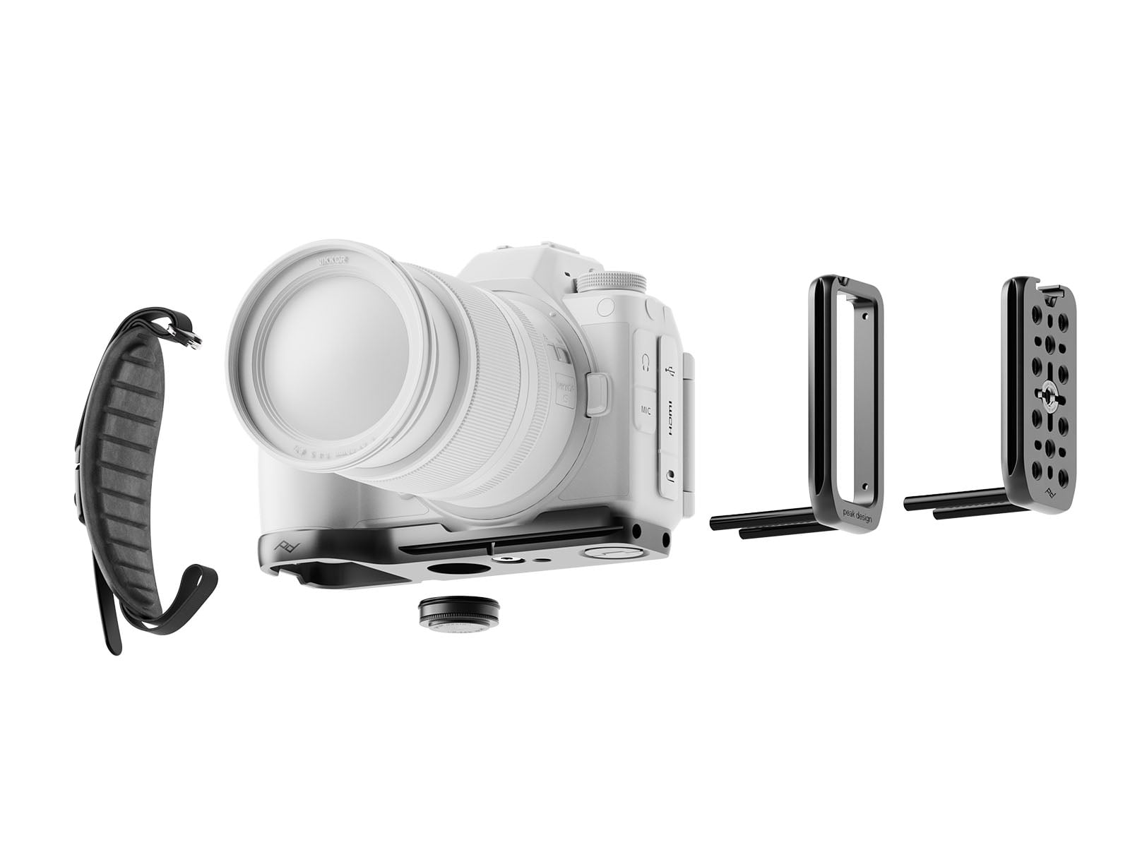 A white digital camera with a lens is shown alongside several black metal mounting accessories and a padded wrist strap, all laid out separately against a white background.