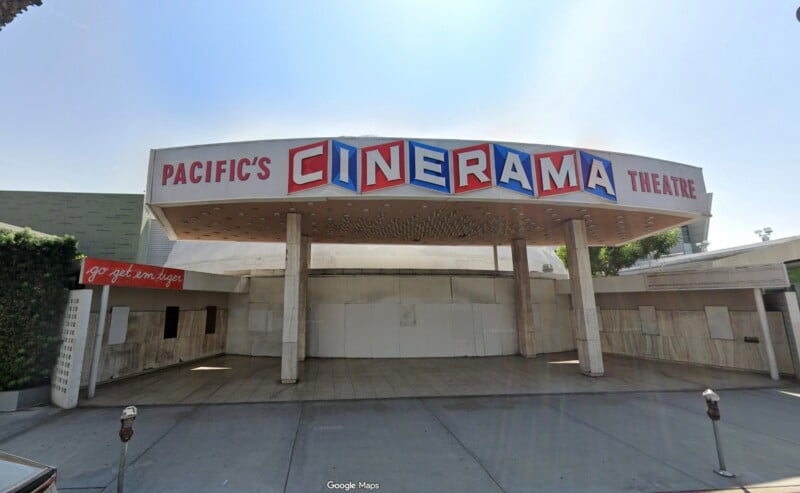 Pacific’s Cinerama Theatre exterior with a retro marquee sign, closed ticket windows, and a covered entrance. Blank white walls and parked meters are visible in front.
