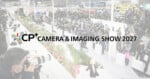 Crowds walk through a busy camera expo with photographers using large lenses. Text reads: 