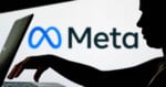 A silhouette of a person using a laptop in front of a screen displaying the Meta logo and name on a white background.